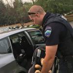 Officer Chase Hawley helps an Islander with questions about car seat safety. Father-to-be Trevor Wong had questions about installing and using a car seat in his vehicle. Photo courtesy of MIPD