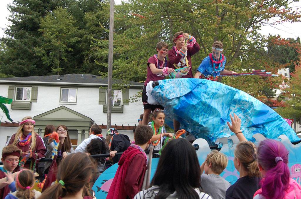 Students on the senior float throw necklaces and candy into the Homecoming Parade crowd. Katie Metzger/staff photo
