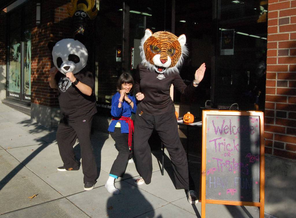 MI Martial Arts instructors Claudia Vleck and Jess Merly pose with student Varenna Ronald during a trick or treat event on Oct. 31. Katie Metzger/staff photo