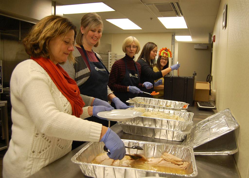 Staffers from the citys Parks and Recreation Department and volunteers from the Mercer Island Womens Club dish up Thanksgiving lunches for seniors. Katie Metzger/staff photo