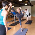 Yogabliss owner Maria Bliss helps a student in class. Each year, Bliss, her teachers and students donate generously to Youth and Family Services through their Practice of Gratitude. Photo via yogabliss.org