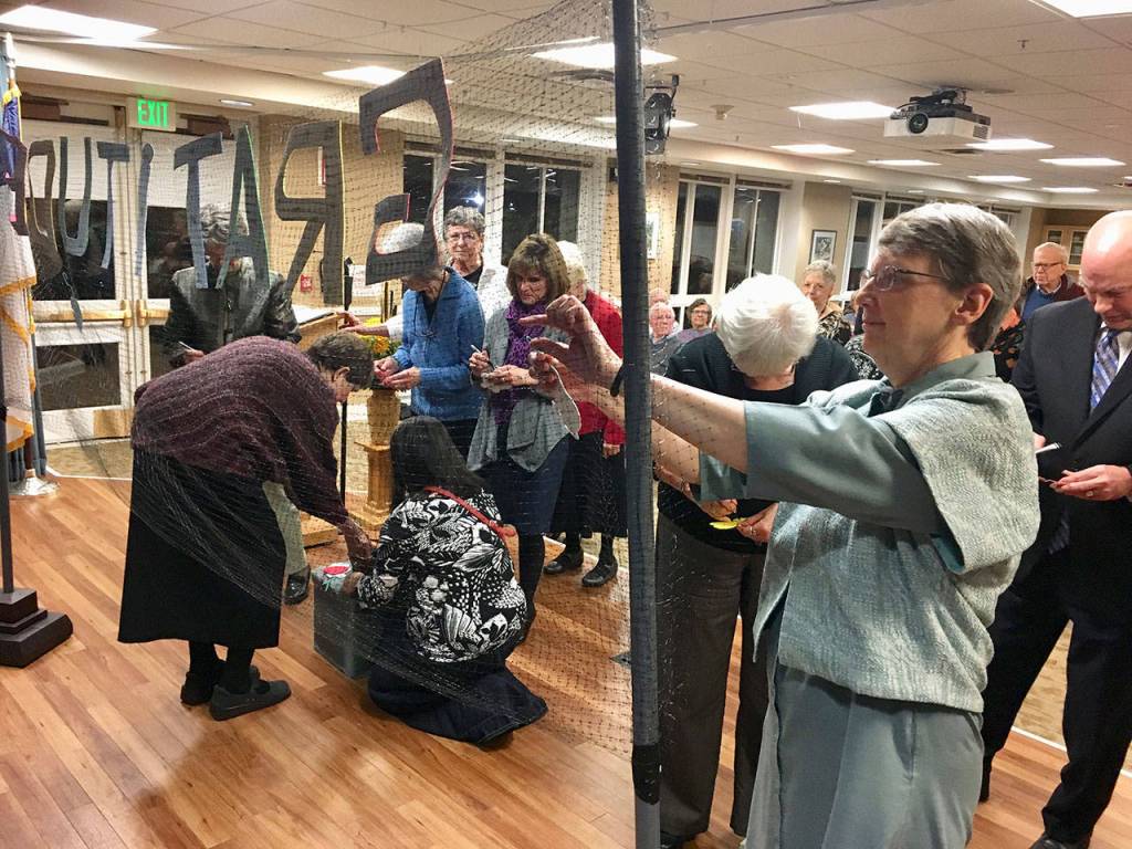 Event attendees hang things on the the wall of gratitude after a community interfaith Thanksgiving service at Covenant Shores on Nov. 19. Photo courtesy of Greg Asimakoupoulos