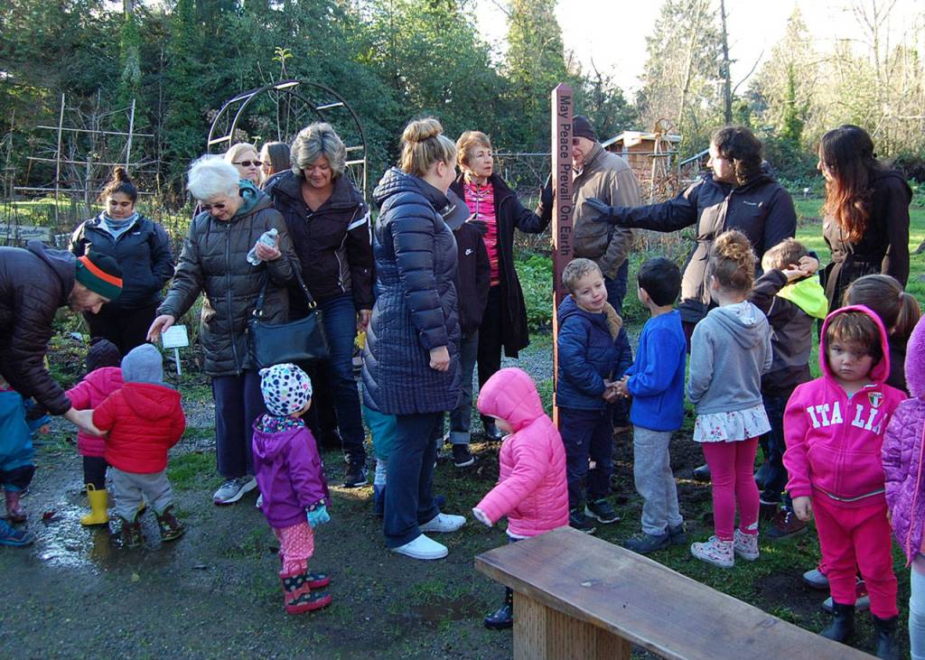 Community members admire the new peace pole in the garden at the Stroum Jewish Community Center after its installation on Dec. 20. Katie Metzger/staff photo