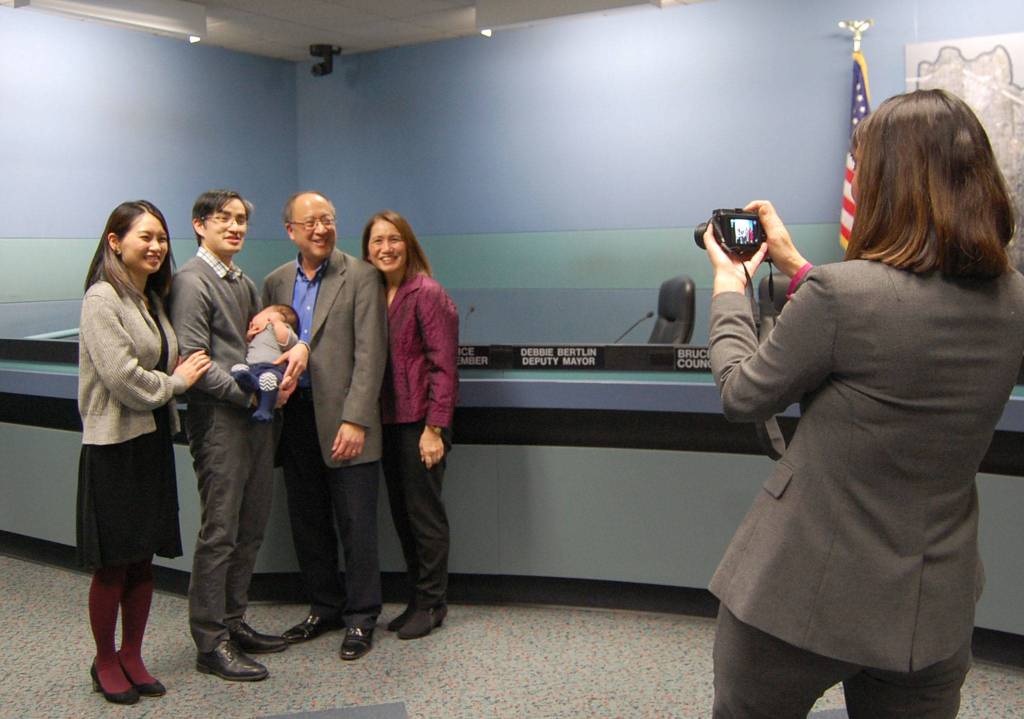 City Manager Julie Underwood photographs Councilmember Benson Wong and family after he was sworn in to another term serving Mercer Island. Katie Metzger/staff photo