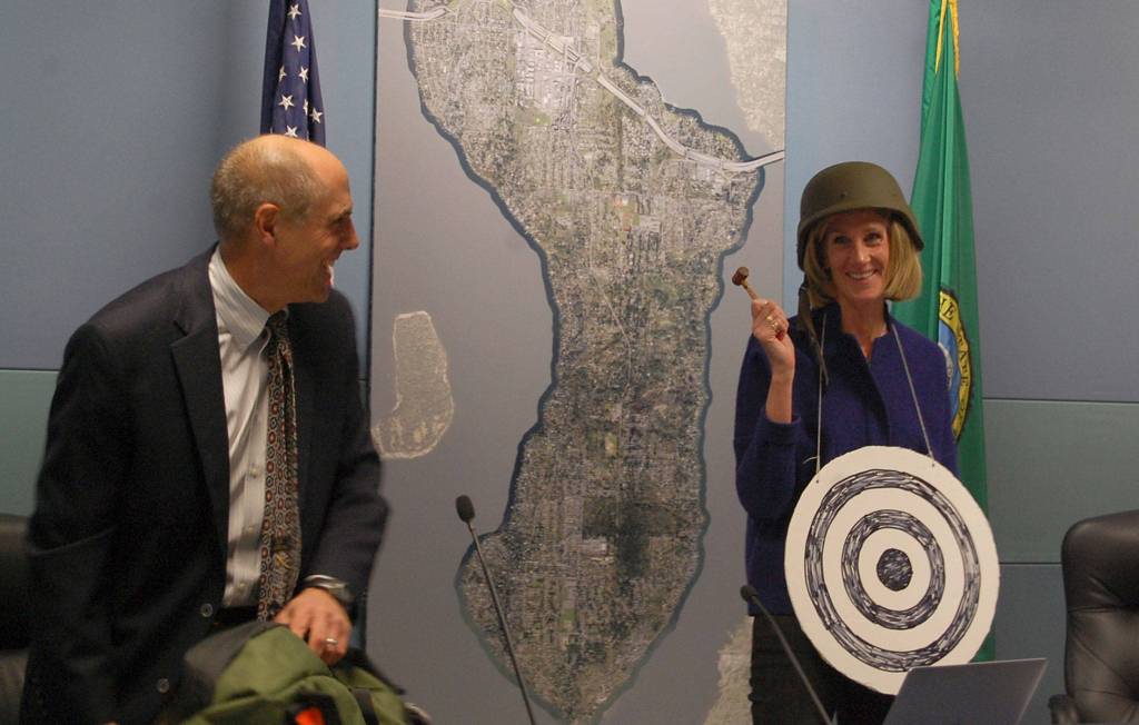 Former Mayor Bruce Bassett gifts Debbie Bertlin with a bulls-eye, helmet and gavel at the Jan. 9 Mercer Island City Council meeting, after Berlin was selected as the new mayor. Katie Metzger/staff photo