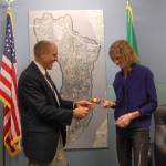 Former Mayor Bruce Bassett passes the gavel to new Mayor Debbie Bertlin at the Jan. 9 Mercer Island City Council meeting. Katie Metzger/staff photo