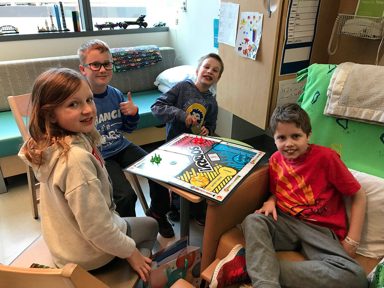 Lakeridge students Piper Auld, Oscar Hokanson, Matthew Duffie and Ewan Lill enjoy a spirited game of Sorry! at Seattle Childrens Hospital after delivering handmade cards from Lakeridge K-Kids Club members to Lill, who is fighting Acute Lymphoblastic Leukemia. Photo courtesy of Julia Hokanson