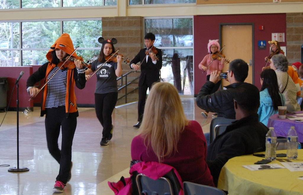 Orchestra students walk in to the performance space at Mercer Island High School, performing Its a Small World. Katie Metzger/staff photo