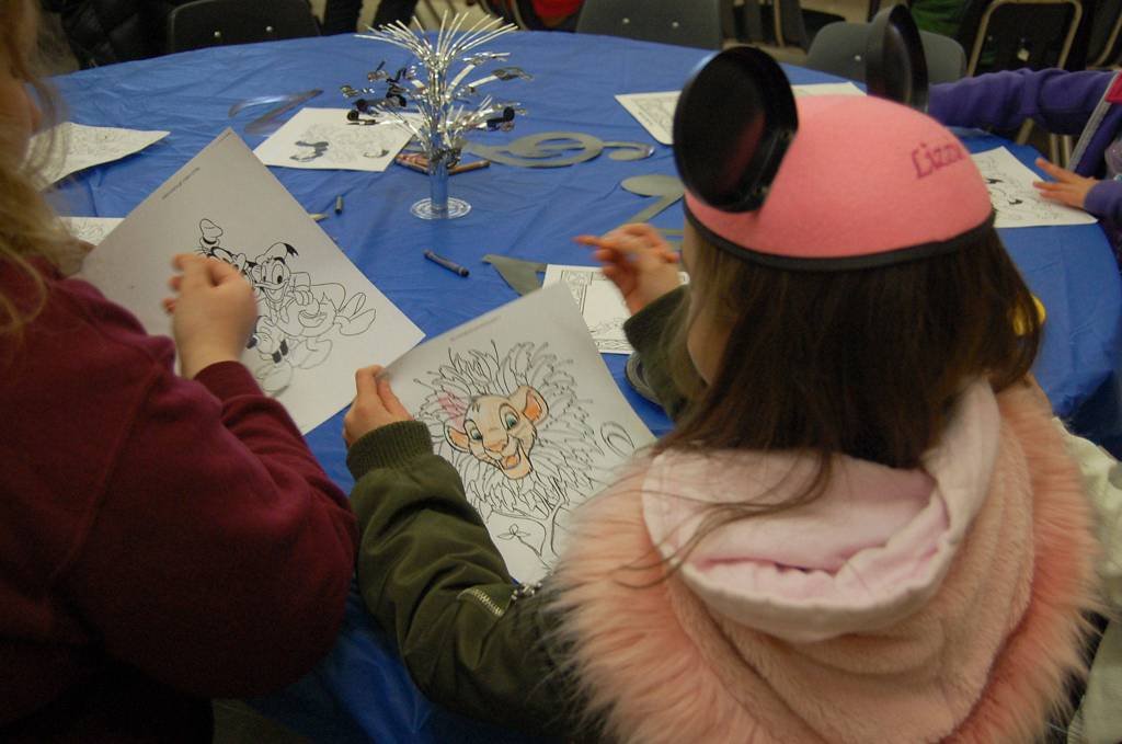 Audience members at Disney and Dessert color pages featuring Goofy, Donald Duck and Simba while waiting for the concert to start. Katie Metzger/staff photo