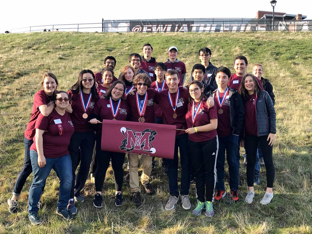 The Mercer Island High School Science Club members pose with a school flag.&nbsp;