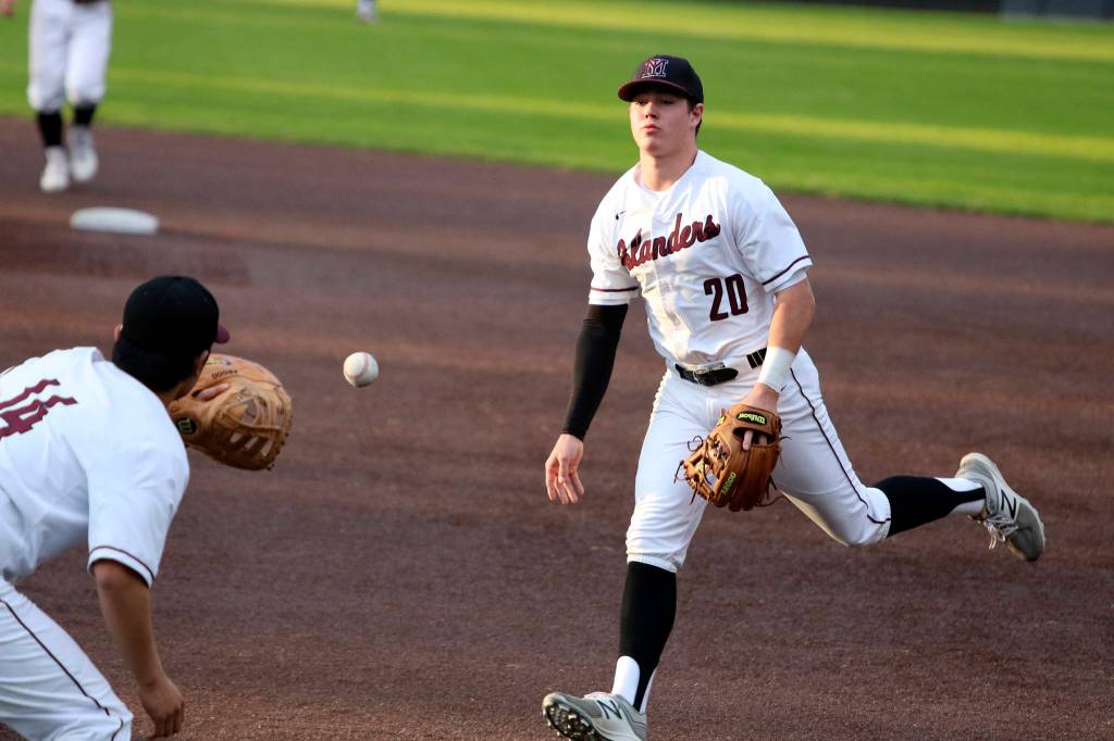 Andy Nystrom, staff photo                                Mercer Island infielder Cole Miller, right, tosses the ball to first baseman Justin Ho for an out in the top of the second inning against the Redmond Mustangs in a KingCo 3A playoff baseball game on May 3 at Bannerwood Park in Bellevue. Mercer Island, which trailed by four runs early in the game, earned a 7-6 comeback win.