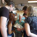Marilyn ONeill and her former students look at a re-enactment of their kindergarten class photo. Katie Metzger/staff photo