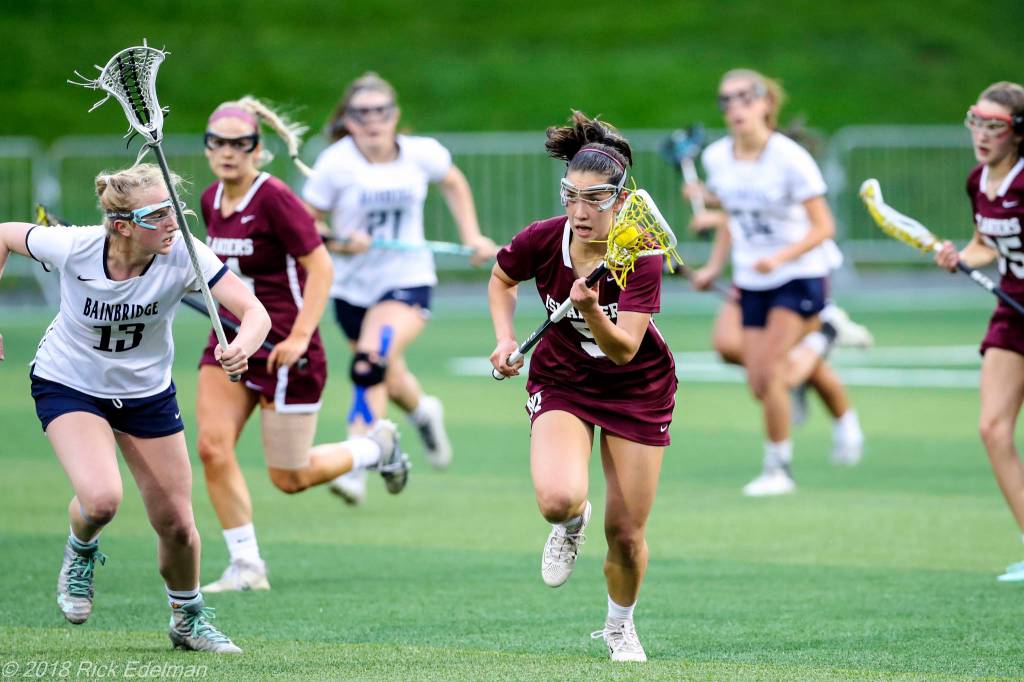 Photo courtesy of Rick Edelman/Rick Edelman Photography                                Mercer Island player Grace Fujinaga, who scored three goals in the state title game, carried the ball upfield while being chased by Bainbridge Island player Maggie Sweeney (left).