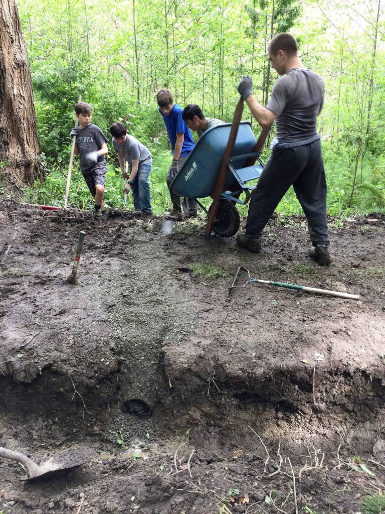 Scouts from Troop 457 dig ditches to enhance the drainage above Mercerdale Park as part of Mark Manginos Eagle Project.