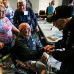 Dick Nelms, 95, enthusiastically shakes hands with Bob Jones, also in his 90s, upon meeting at the Stanwood Eagles on Thursday. More than 20 former military pilots gathered to hear Nelms speak of flying 35 combat missions in a B-17 during World War II. (Dan Bates / The Herald)