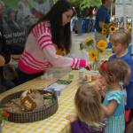 Volunteers at the childrens table at the Mercer Island Farmers Market teach kids how to plant sunflowers. Katie Metzger/staff photo