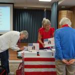 Author Karen Robbins sells and signs copies of her book, Flags Across America, on June 14. Katie Metzger/staff photo