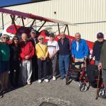 From right, Covenant Shores staff Roxanne Helleren and Leslie McGee pose with sponsor Sports Clips Andrea Wick, resident Bob Weber, pilot Mike Sommars and residents Bette Bjornestad, Ron Ross, Charlie Hammer, Owen Hall, Zip Zuther and Joe Morton.