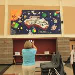 A woman photographs a mural by the MIHS Class of 2018. Katie Metzger/staff photo