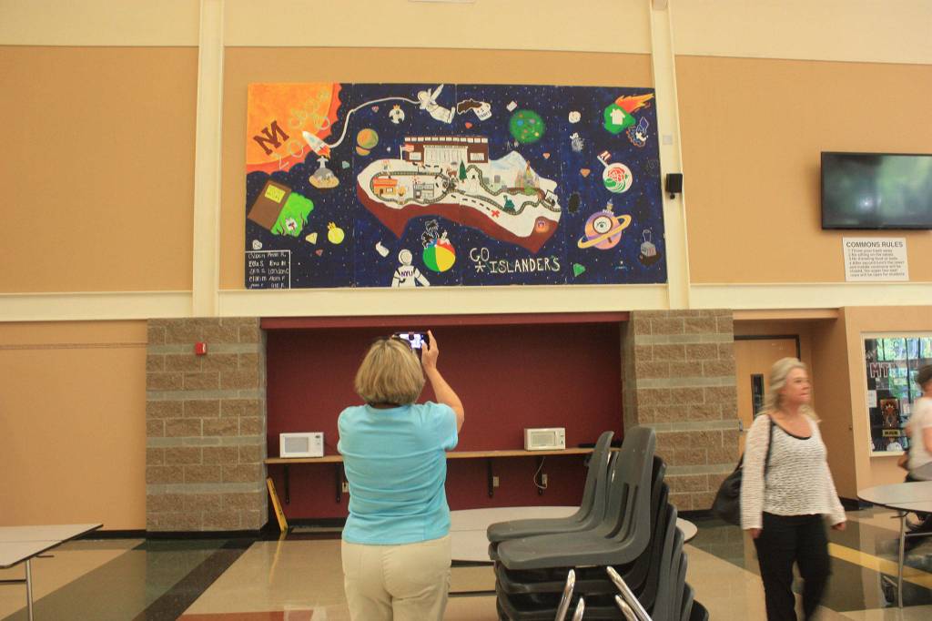 A woman photographs a mural by the MIHS Class of 2018. Katie Metzger/staff photo