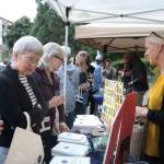 Island Books owner Laurie Raisys talks to customers at Art Uncorked on Sept. 7. Katie Metzger/staff photo