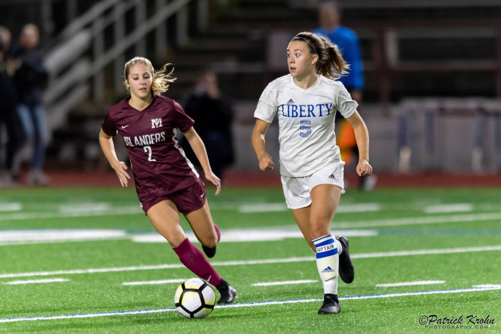 Mercer Island senior midfielder Emily Arron, left, puts pressure on Liberty defender Cameron Nelson, right, in a matchup featuring two of the top soccer programs in the 3A/2A KingCo Division. Mercer Island earned a 2-1 comeback victory on Sept. 25 on Mercer Island. Photo courtesy of Patrick Krohn/Patrick Krohn Photography