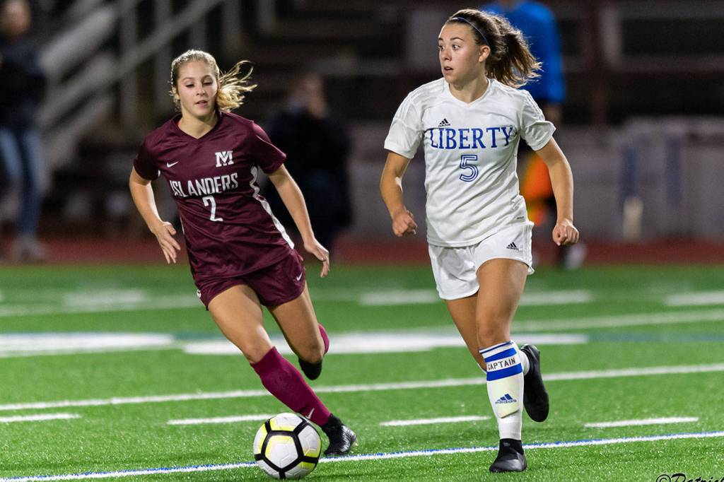 Mercer Island senior midfielder Emily Arron, left, puts pressure on Liberty defender Cameron Nelson, right, in a matchup featuring two of the top soccer programs in the 3A/2A KingCo Division. Mercer Island earned a 2-1 comeback victory on Sept. 25 on Mercer Island. Photo courtesy of Patrick Krohn/Patrick Krohn Photography