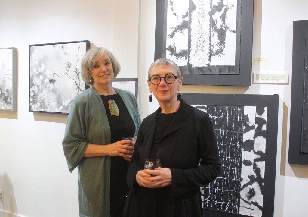 Karen Dedrickson and Chris Baumgartner pose in front of their artwork at Clarke and Clarke Art and Artifacts on Mercer Island. Katie Metzger/staff photo