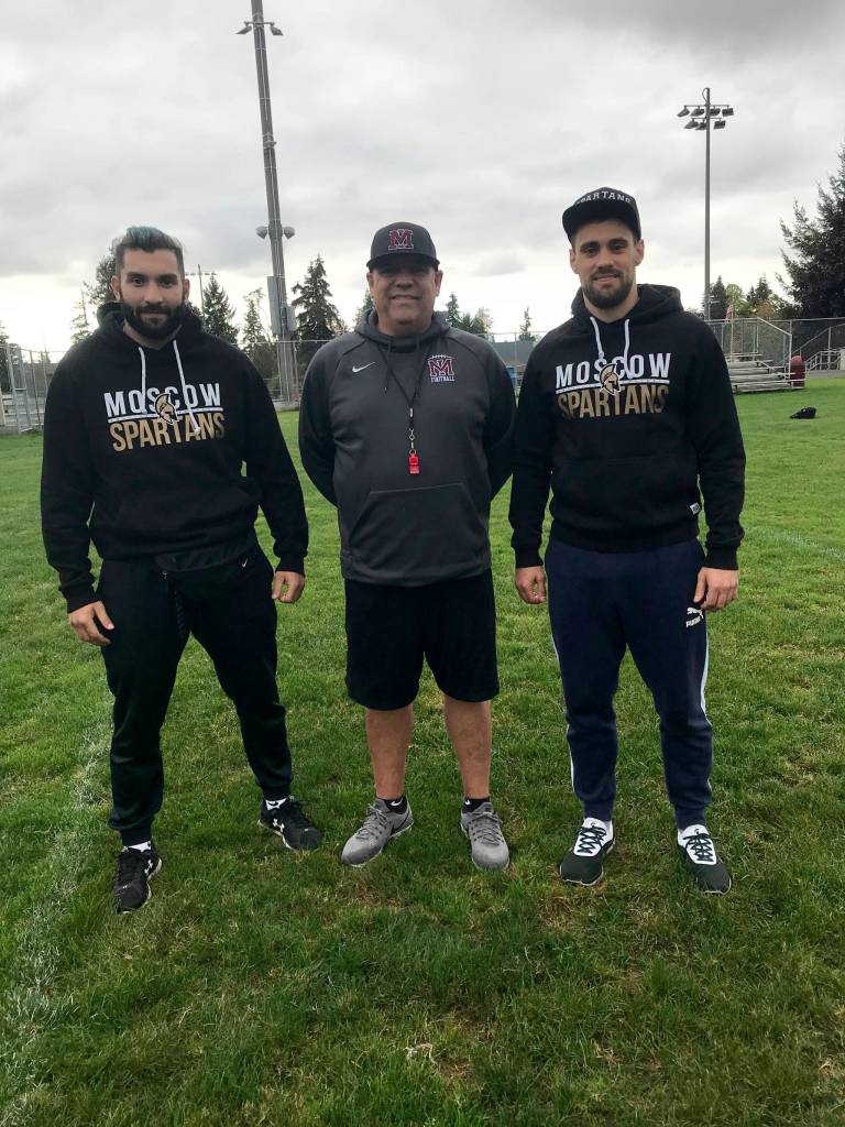 Moscow Spartans football players Omari Grinyaev, Michael Levenshtein and Mercer Island head football coach Ed Slezinger pose for a quick photo prior to the start of Mercer Islands football practice on Oct. 9. Grinyaev and Levenshtein will be in Washington observing the Islanders football programs practices, meetings, workouts and games through Oct. 22. Shaun Scott/staff photo