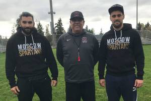 Moscow Spartans football players Omari Grinyaev, Michael Levenshtein and Mercer Island head football coach Ed Slezinger pose for a quick photo prior to the start of Mercer Islands football practice on Oct. 9. Grinyaev and Levenshtein will be in Washington observing the Islanders football programs practices, meetings, workouts and games through Oct. 22. Shaun Scott/staff photo