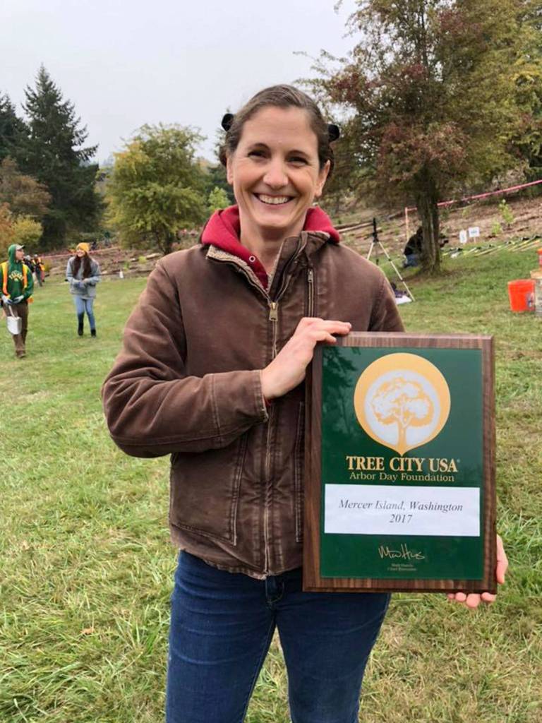 Alaine Sommargren, the citys natural resources manager, shows off a plaque designating Mercer Island as a Tree City USA. Photo courtesy of Julie Underwood