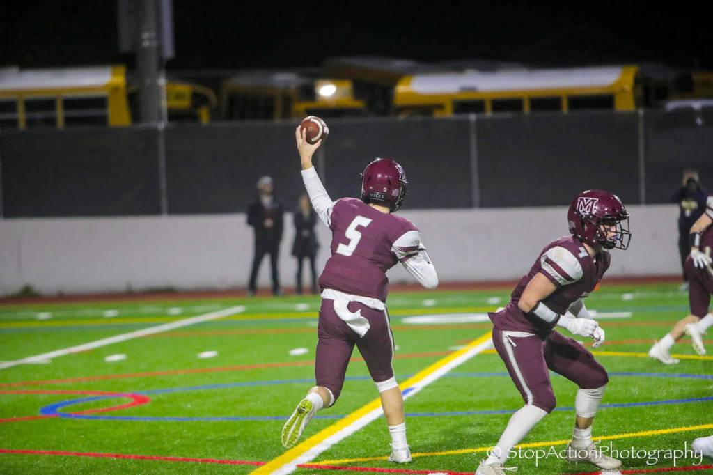 Mercer Island junior quarterback Clay Dippold, left, prepares to throw the ball while senior running back Jack Clayville, right, prepares to block a Bellevue defender. Photo courtesy of Don Borin/Stop Action Photography