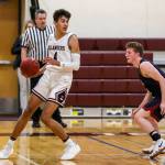 Mercer Island Islanders junior Adam Parker, left, looks for a teammate to pass to against the Juanita Rebels. Parker finished with a team-high 20 points against the Juanita Rebels on Dec. 11. The Islanders defeated the Rebels 56-49. Photo courtesy of Rick Edelman/Rick Edelman Photography