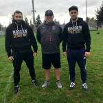 Moscow Spartans football players Omari Grinyaev, Michael Levenshtein and Mercer Island head football coach Ed Slezinger pose for a quick photo prior to the start of Mercer Islands football practice on Oct. 9. Grinyaev and Levenshtein were in Washington observing the Islanders football programs practices, meetings, workouts and games through Oct. 22. Shaun Scott/staff photo
