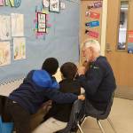 John Hamer of the Mercer Island Rotary Club tutors students at Van Asselt Elementary School in South Seattle. Photo courtesy of Nancy Lee