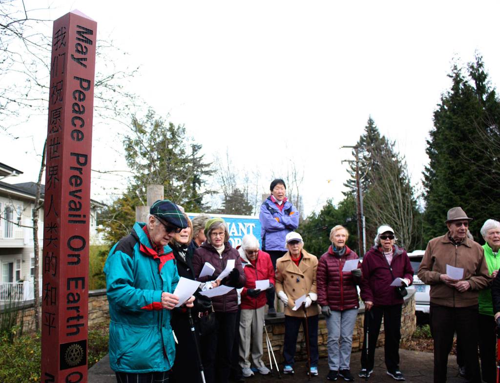 Covenant Shores residents sing Let There Be Peace on Earth after the unveiling of their communitys new peace pole. Katie Metzger/staff photo