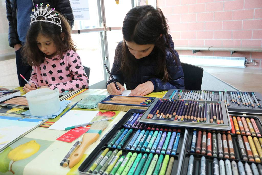 Sofia Gusu, 6, and Iana Gusu, 8, from Redmond, draw butterflies with water soluble colored pencils at a Northwest Artists in Action pop-up at the Mercer Island Community and Event Center on Jan. 26. Katie Metzger/staff photo