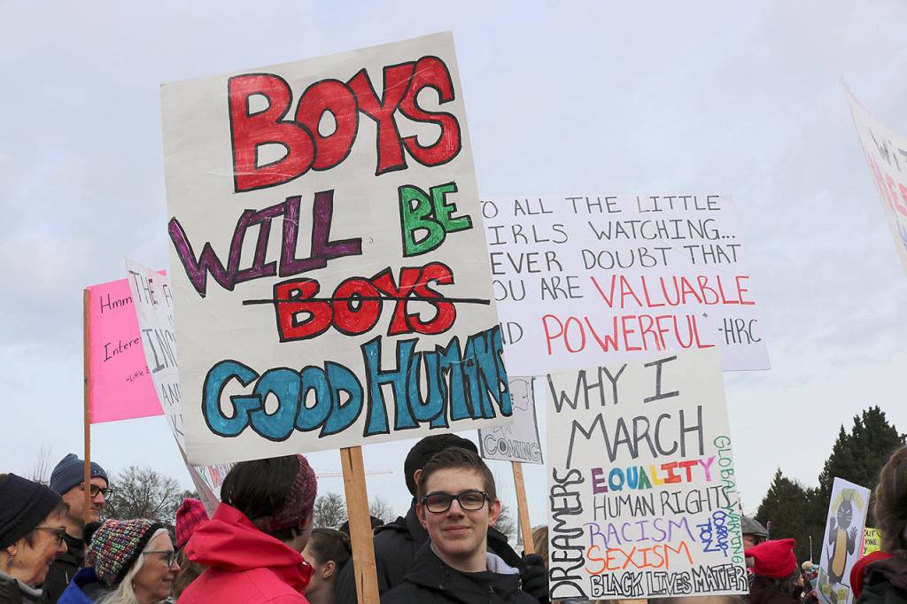 Young boy carries a sign that reads, Boys will be good humans. Stephanie Quiroz/staff photo.