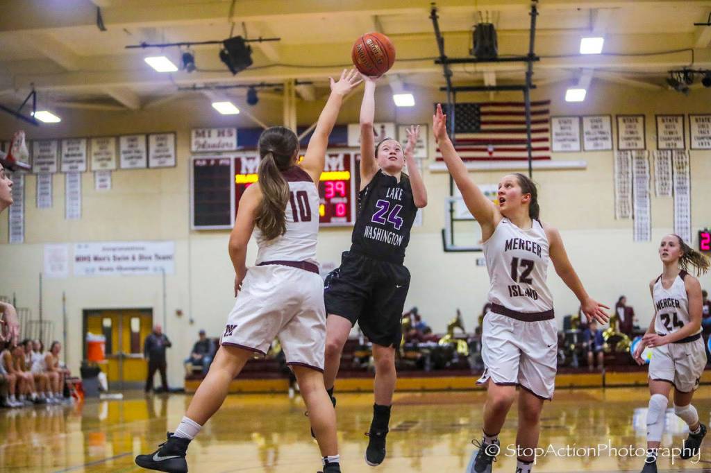 The Lake Washington Kangaroos girls basketball team captured a 64-53 win against the Mercer Island Islanders on senior night on Jan. 30 at Mercer Island High School. The Islanders dropped to 1-18 overall with the loss. Mercer Island seniors Sarah Gest, right, and Rio Beutelspacher, left, try to stop Lake Washington guard Rosa Smith, center, as she drives to the hoop. Photo courtesy of Don Borin/Stop Action Photography