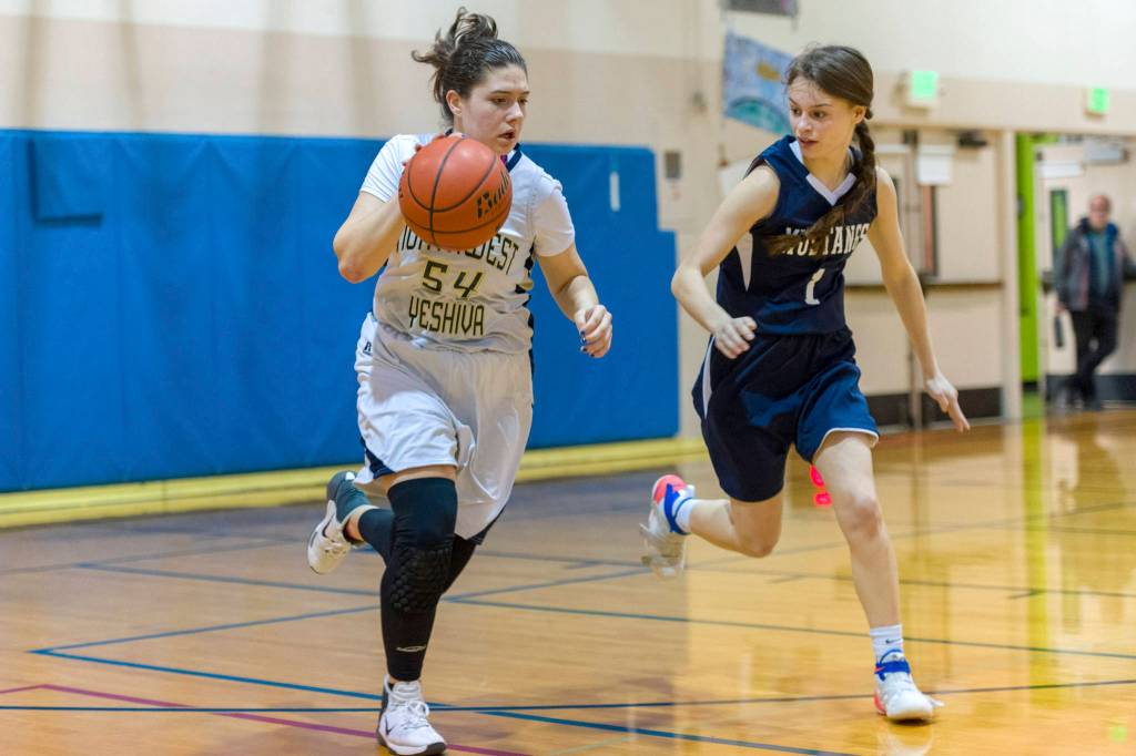 Northwest Yeshiva senior Zohar Hemmet, left, dribbles the ball down the court in the final game of her high school career against Rainier Christian on Jan. 30. Northwest Yeshiva finished the 2018-19 season with an overall record of 4-16. Photo courtesy of Patrick Krohn/Patrick Krohn Photography