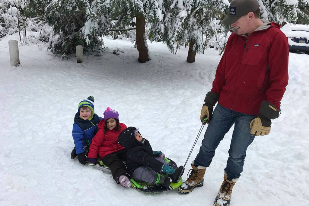 All aboard and ready to roll  Front to back: Niko Hallman, 2, Leela Hallman, 4, and Logan Dais, 3, are pulled on a sled by Matt Hallman. Photo courtesy of Meg Lippert