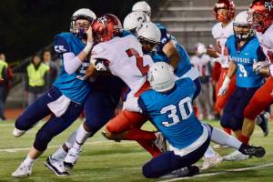 Auburn Riverside defenders bring down Kennedy Catholics Junior Alexander during North Puget Sound League Mountain Division action in Oct. 2018 at Auburn Memorial Stadium. Photo by Rachel Ciampi/Auburn Reporter