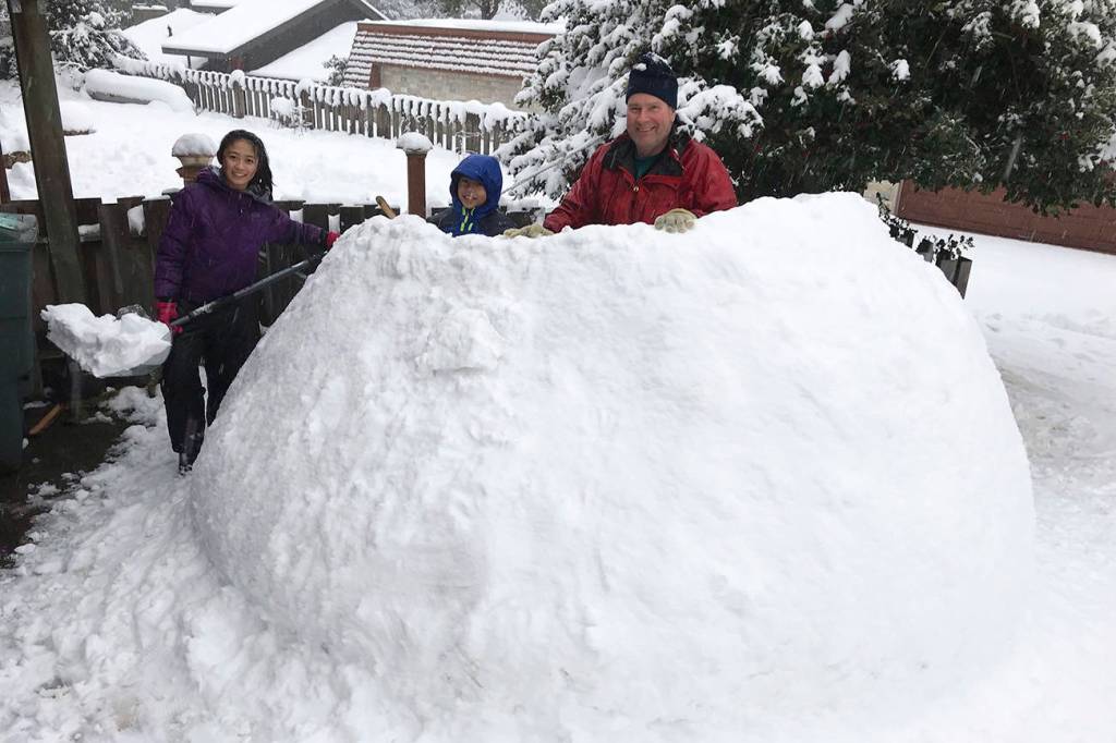 Jayne, Dan and Derek take a break to pose for a photo while building an igloo on Mercer Island. Photo courtesy of Meg Lippert