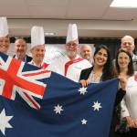 Chef Steve Laybourn, Covenant Shores Dining Director Neetu Saini, Executive Director Bob Howell, Chef Laura Gabriel and more pose with an Australian flag after a cooking demonstration on March 1, when residents of the Mercer Island retirement community got to try kangaroo and alligator. Katie Metzger/staff photo