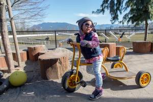 Vivian, one of many cared for at a child care center of the Kiwassa Neighbourhood House in Vancouver, B.C., spends the day outside on a tricycle on March 21. The site was awarded prototype status by the government of British Columbia as part of an effort to ease skyrocketing child care costs in the province. Ashley Hiruko/staff photo
