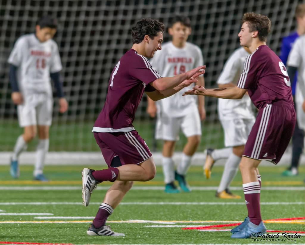 Mercer Island junior midfielder Luca Mtskhetadze, left, celebrates with teammate Jonah Hyman, right, after scoring on a header in the 87th minute of play, giving his team a 2-1 lead in overtime. Mercer Island held on for a 2-1 victory against the Juanita Rebels on April 11. Photo courtesy of Patrick Krohn/Patrick Krohn Photography