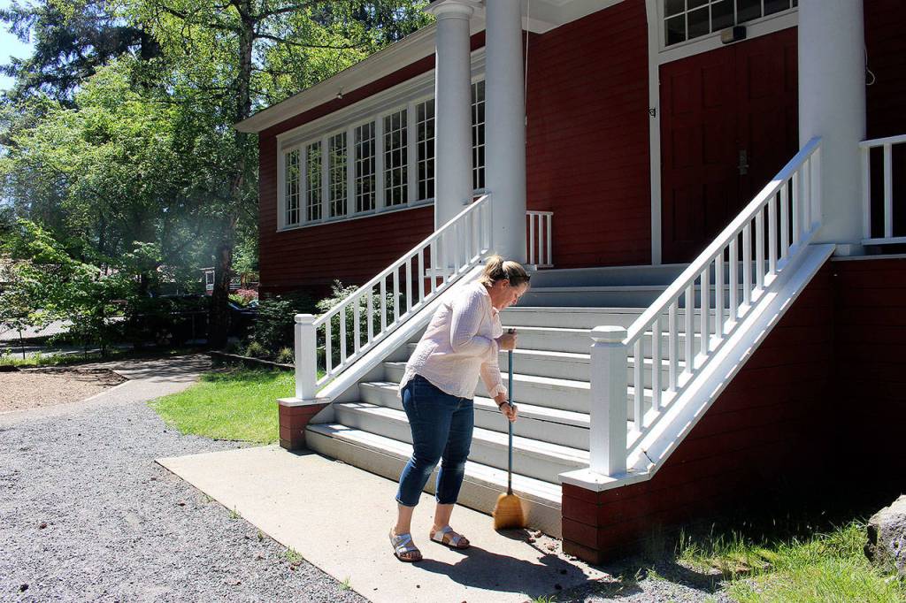Liz Carson, Sunnybeam Schools director, sweeps away gravel from the schools stairs. Madison Miller / staff photo