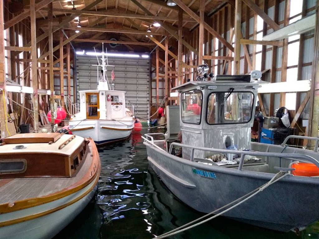 Dunatos Boat Yard is building a smaller vessel, seen on the right, which will be used for reclamation efforts on Lake Sammamish and smaller waterways in the area. Aaron Kunkler/staff photo