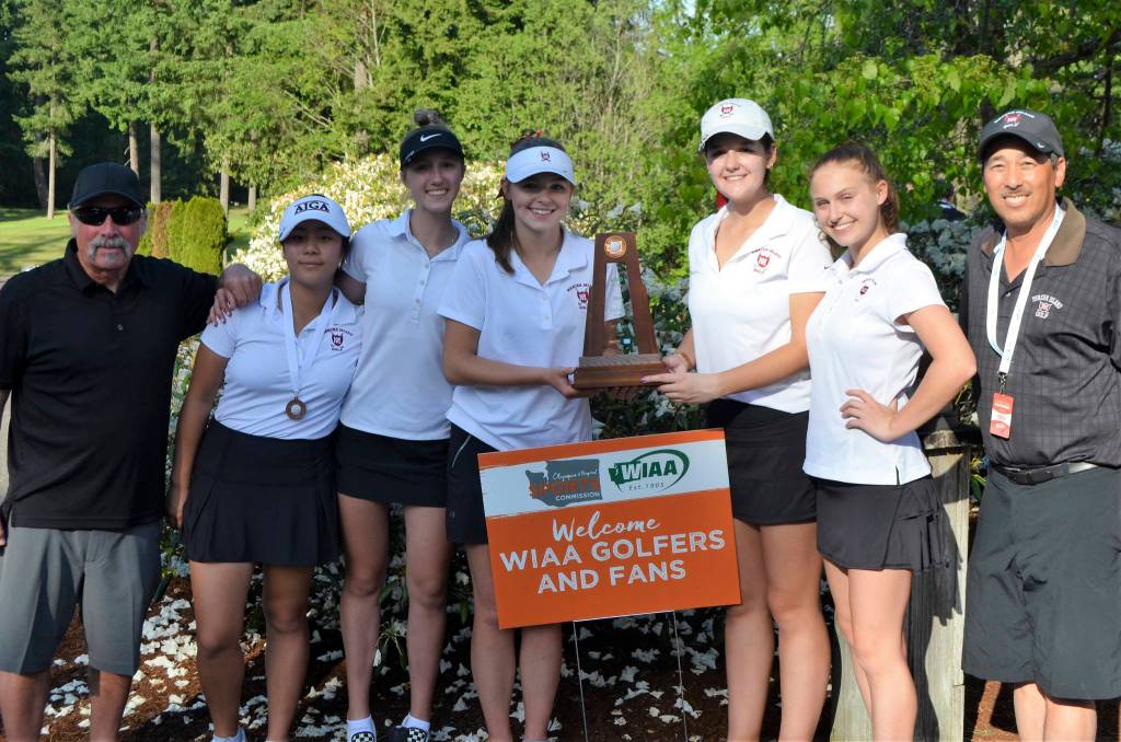 Coach Don Papasedero, Gihoe Seo, Grace Shaddle, Annelise Rorem, Katelyn Travis, Lilly Pruchno and coach Tim Okamura take a team photo with the 3A third place trophy on May 22 at Hawks Prairie Golf Course in Lacey. Photo courtesy of Billy Pruchno