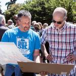 Mark LeMaster and Stu Harris look at past class photos during the East Seattle Elementary School alumni event on June 8. Photo courtesy of Owen Blauman